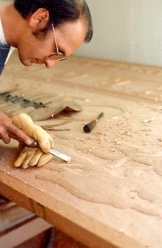 Luis Villarreal carving a panel at the bench